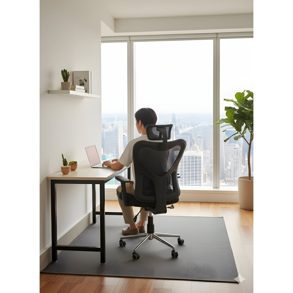 Neva Edge chair viewed from behind as a person works at a desk beside large windows