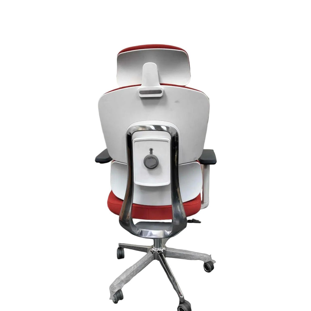 Neva Axis padded chair from behind, showing the light-coloured back shell, rear knob and wrapped base legs