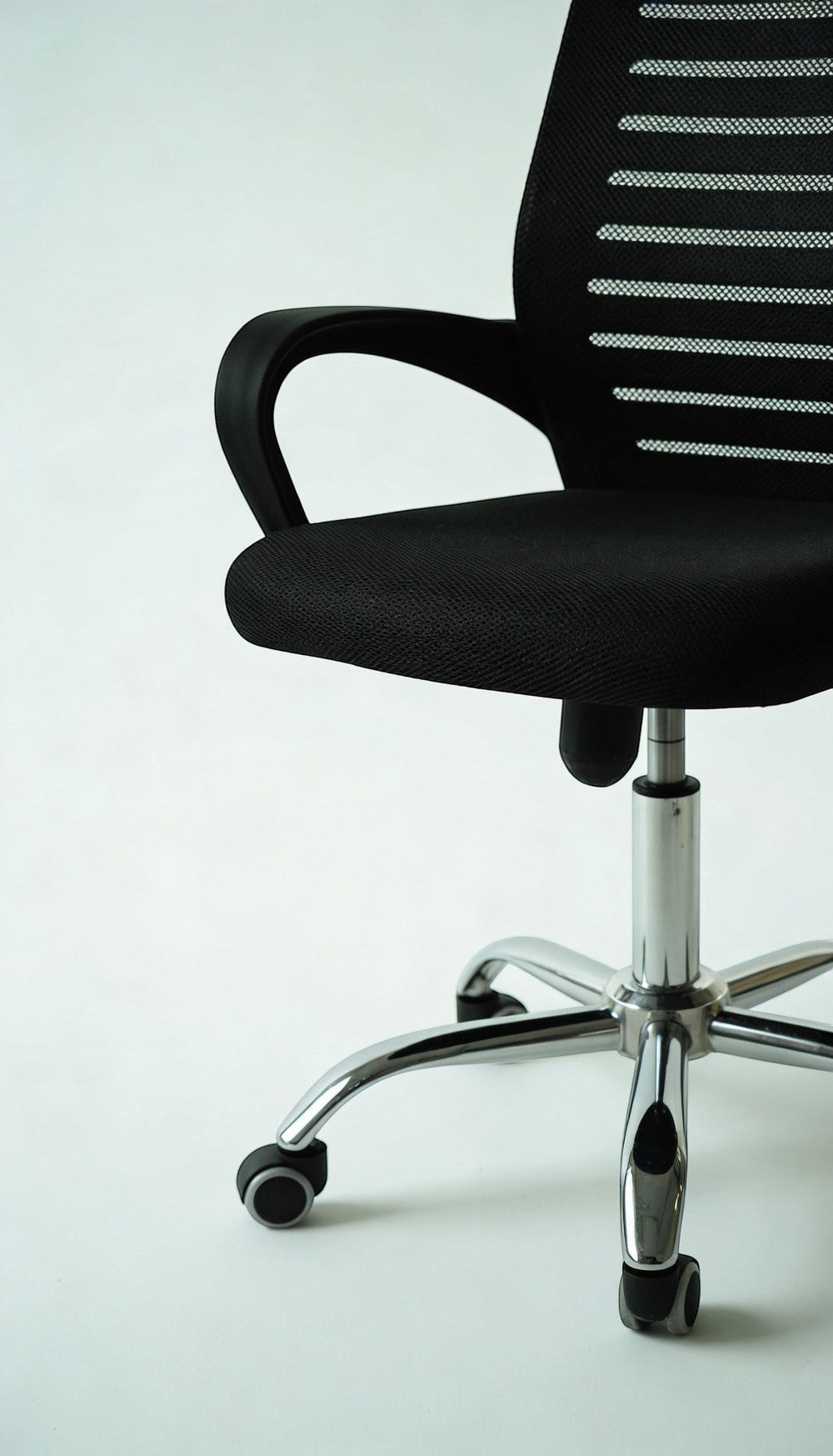 Neva Furniture black mesh office chair with ergonomic support and chrome base with casters.