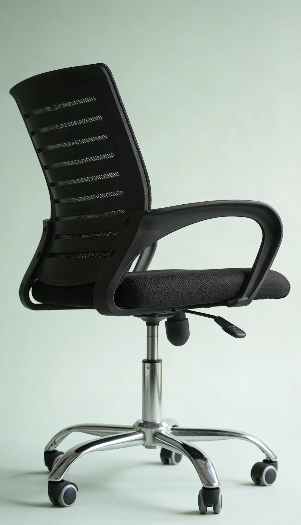 Neva Furniture black mesh office chair with ergonomic support and cushioned seat, on a chrome base with casters.
