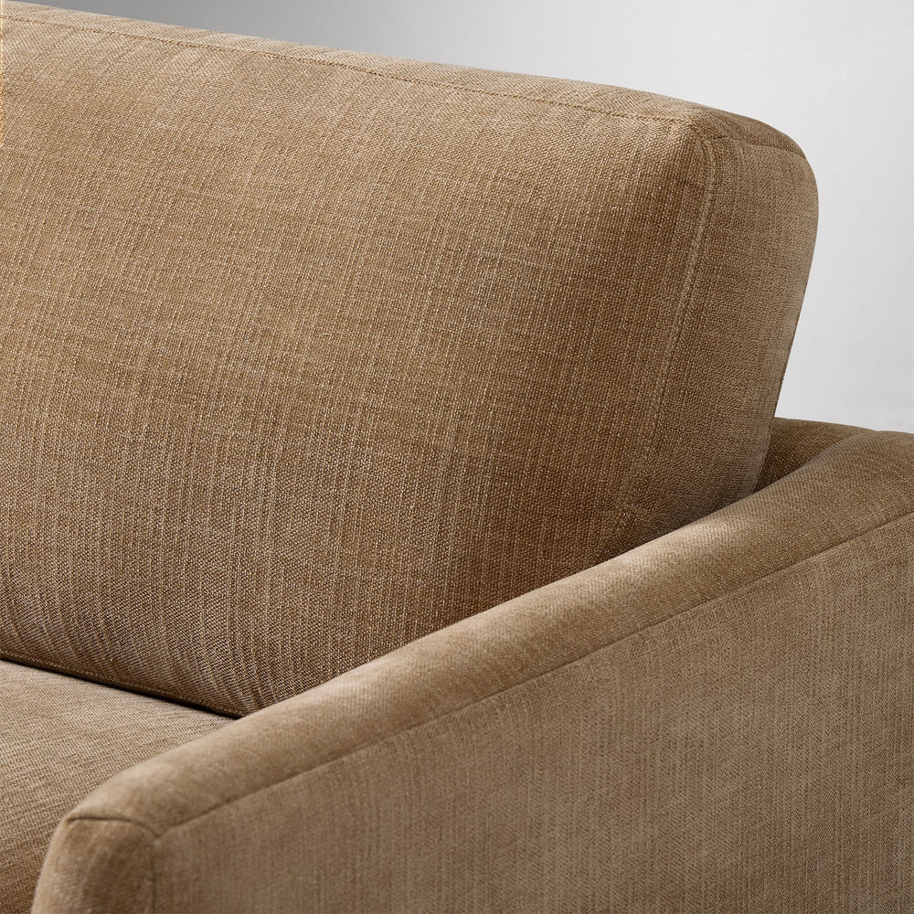 Close-up of a brown fabric sofa with a neutral background