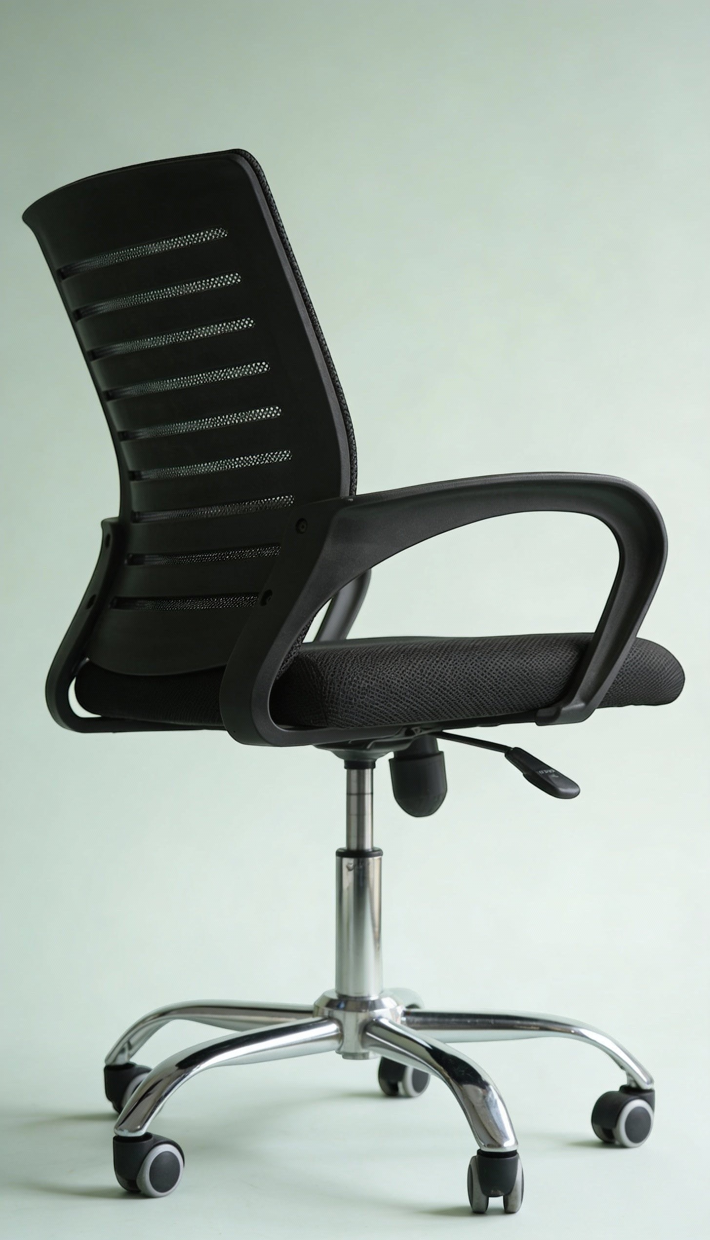 Neva Furniture black mesh office chair with ergonomic support and cushioned seat, on a chrome base with casters.