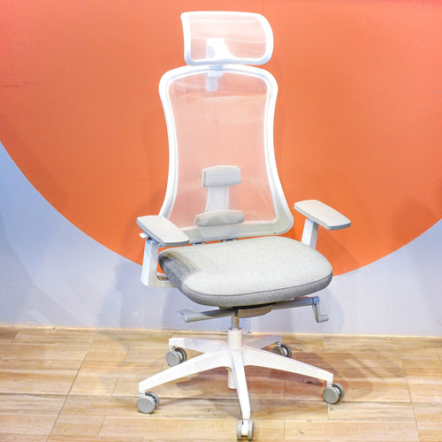 Neva Furniture white mesh ergonomic office chair with adjustable lumbar support and grey fabric seat, on a wooden floor.