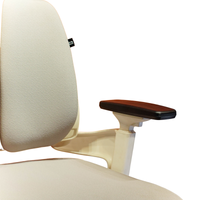 Neva Prime White chair close-up of the padded backrest, black armrest pad and white armrest support.