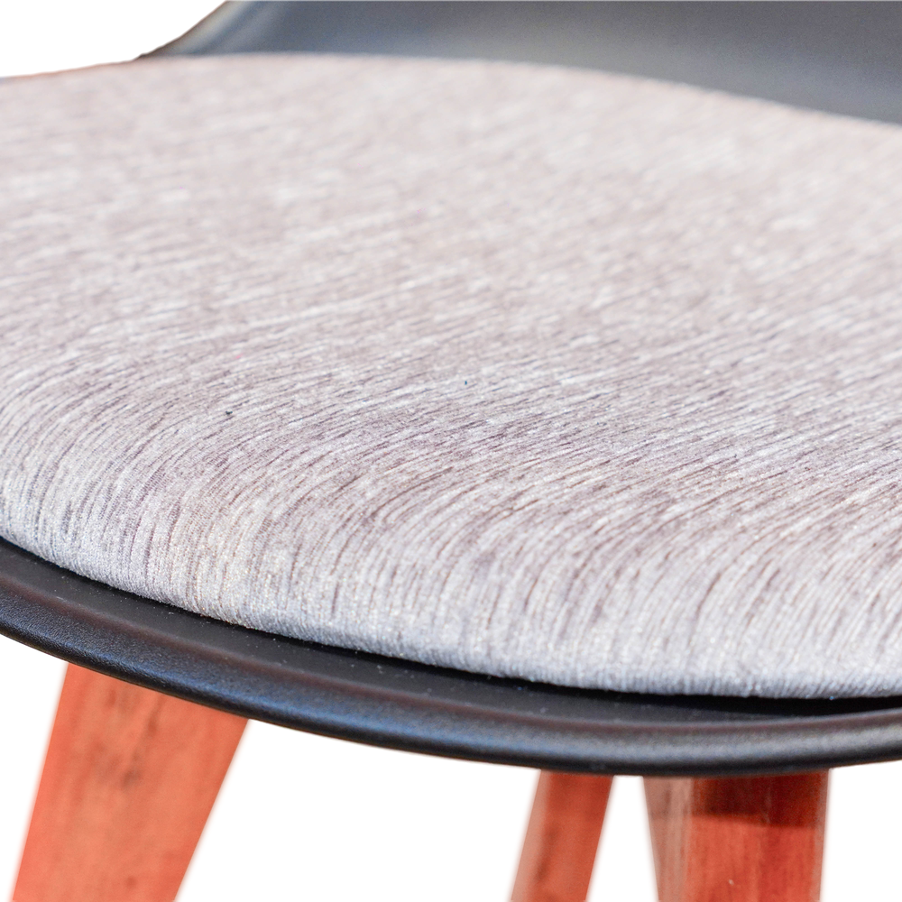 Neva Tulip Black shell chair, close-up of the pale woven fabric cushion, rounded seat rim and wooden legs