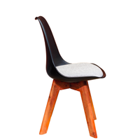 Neva Tulip Black shell chair, side view showing the curved back, raised seat rim and tapered wooden legs
