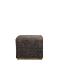 Brown cube-shaped ottoman on a wooden floor with a gray wall background